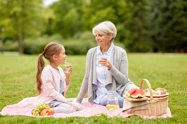 grandmother and granddaughter at picnic in park - Photo, image