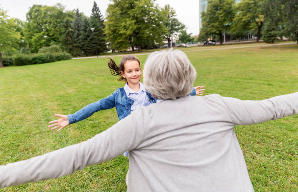 grandmother and granddaughter playing at park - Фото, изображение