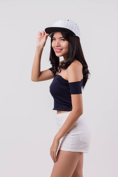 cute happy smiling woman wearing cap. portrait of positive optimistic urban woman with modern fashion, studio white isolated with friendly girl face. young adult beautiful girl asian woman model - Photo, Image