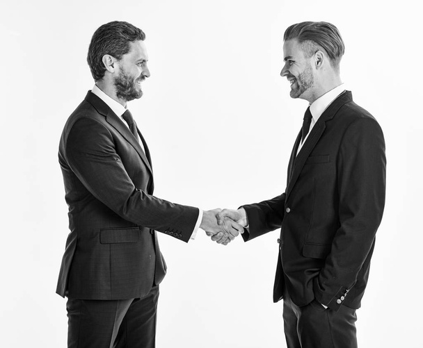 Men in suits or businessmen hold hands in handshake. - 写真・画像
