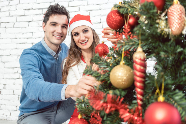 Couple at home decorating tree for Christmas - Foto, Imagem