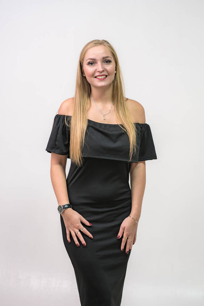 portrait of a beautiful blonde girl in a dress on a white background. She stands right in front of the camera in different poses and shows different emotions - Fotó, kép
