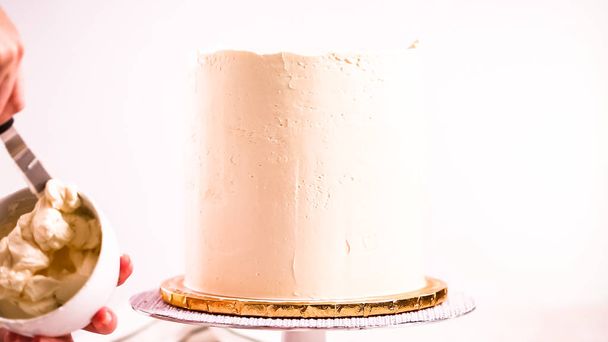Baker frosting pink and purple cake with a white buttercream icing. - Photo, Image