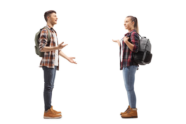Full length profile shot of teenage students talking with each other isolated on white background - Photo, image
