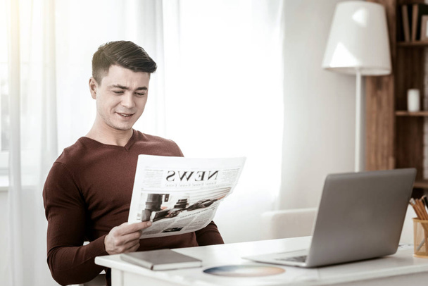 Pleased young man checking news in the country - Foto, Bild