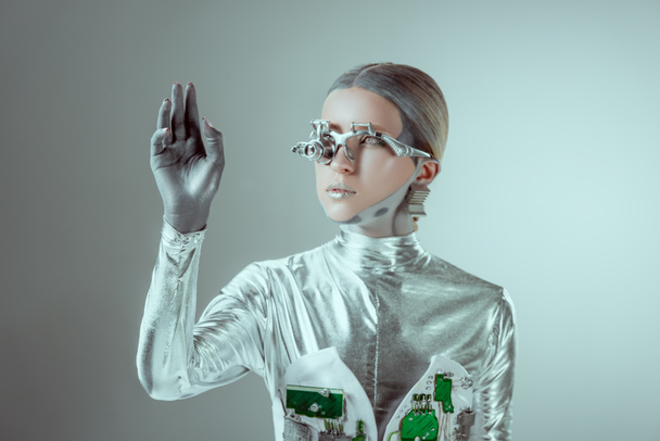 robot de plata futurista gesto con la mano y mirando hacia otro lado aislado en gris, el concepto de la tecnología del futuro
   - Foto, imagen