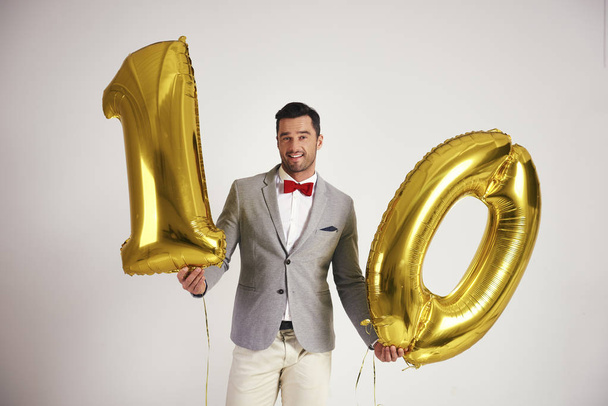 Mladý muž s zlaté bublině budování se číslice "10" - Fotografie, Obrázek