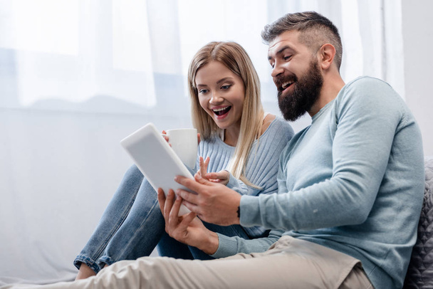 Couple in casual clothing using digital tablet  - Φωτογραφία, εικόνα