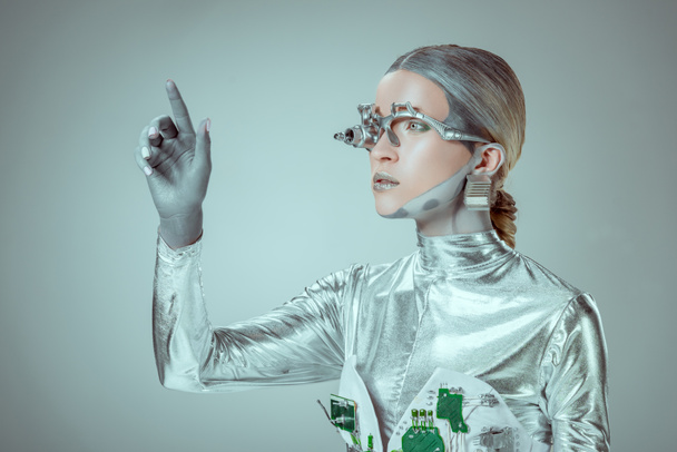futuristico robot d'argento gesticolare con mano e distogliere lo sguardo isolato sul grigio, concetto di tecnologia futura
   - Foto, immagini