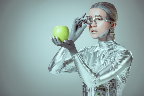 robot che esamina la mela verde isolata sul grigio, concetto tecnologico futuro
 - Foto, immagini