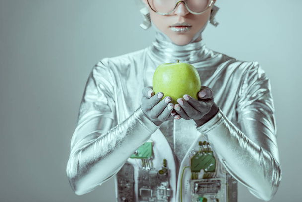 cropped shot of cyborg holding green apple isolated on grey, future technology concept - Fotoğraf, Görsel