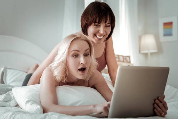 Two ladies watching laptop being shocked by the content - 写真・画像