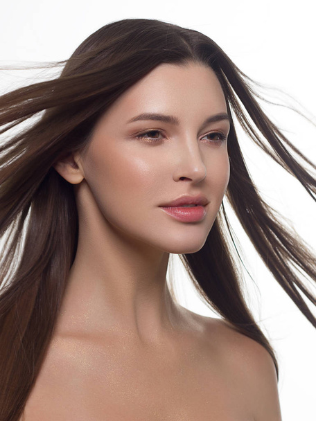 Close-up of beauty girl with long straight developing hair and radiant daytime makeup on her face. Skin care natural cosmetics in the spa salon or cosmetology. - Foto, Imagem