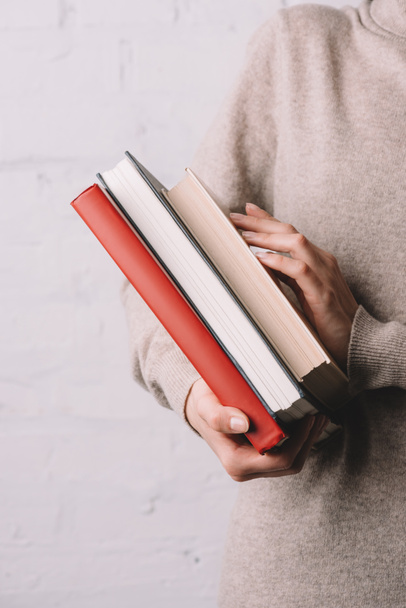 close-up partial view of young woman holding books - Foto, Imagem