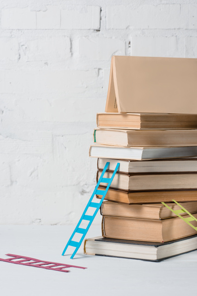 close-up view of pile of books and small colorful step ladders  - Фото, изображение
