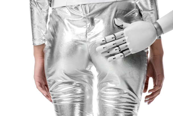 cropped image of robot touching buttocks of woman in silver clothes isolated on white, future technology concept - 写真・画像