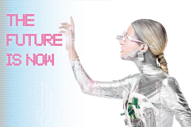 Seitenansicht von silbernem Cyborg mit Schriftzug "Die Zukunft ist jetzt" isoliert auf Weiß mit digitalen Daten - Foto, Bild