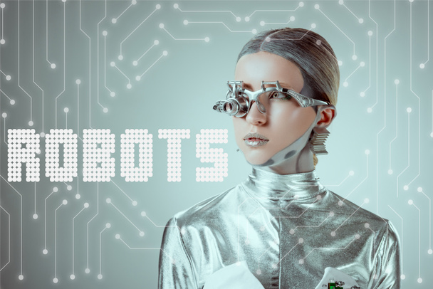futuristinen hopea kyborgi etsii pois eristetty harmaa "robotit" kirjoitus ja digitaalista dataa
 - Valokuva, kuva