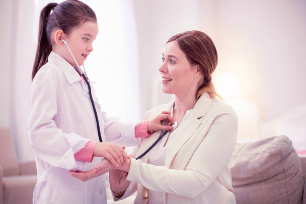 Caring family physician playing with her client examining girl - Photo, image