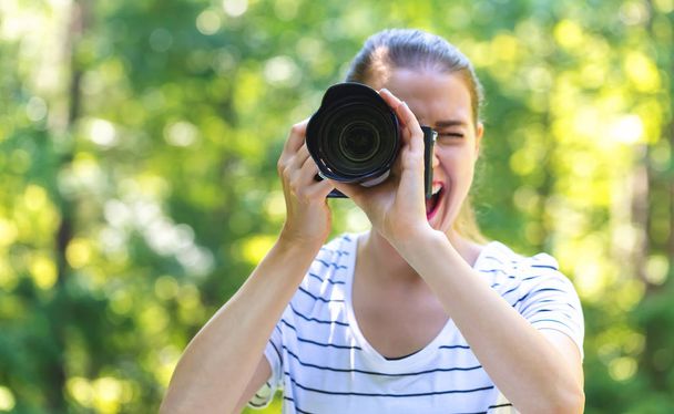 Young woman with a professional camera - Zdjęcie, obraz