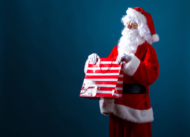 Santa sosteniendo una bolsa de compras
 - Foto, Imagen