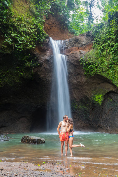 バリ島の豪華な滝を見てカップル - 写真・画像