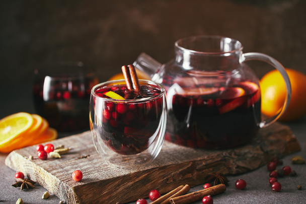 homemade mulled wine with cranberries on wooden stand in kitchen - Photo, Image