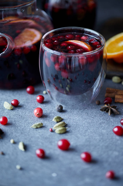 selective focus of tasty homemade mulled wine with cranberries and oranges on table in kitchen - Fotografie, Obrázek