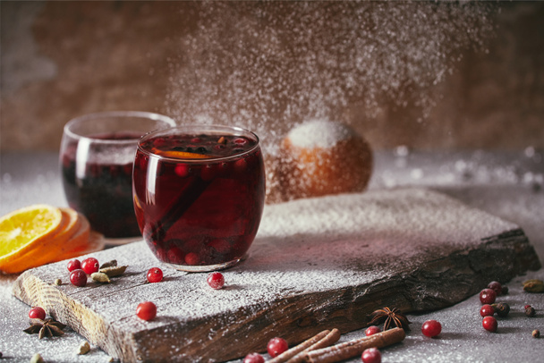chaud maison vin chaud chaud aux canneberges avec sucre en poudre tombant sur la table dans la cuisine
 - Photo, image