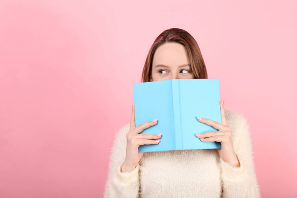 Young girl with book on pink background - Photo, Image