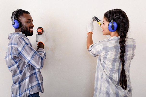 couple making renovation of home with drill and hammer together - 写真・画像