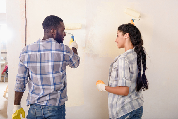 молодая счастливая пара картина стены во время ремонта дома
 - Фото, изображение
