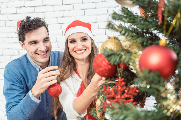 Couple at home decorating tree for Christmas - Φωτογραφία, εικόνα