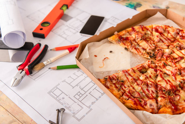 крупный план коробки с пиццей, инструментами и смартфоном по плану строительства
 - Фото, изображение
