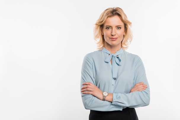 beautiful confident businesswoman standing with crossed arms and smiling at camera isolated on white - Valokuva, kuva