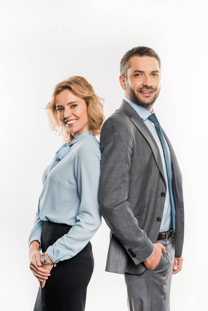 side view of professional  businessman and businesswoman standing together and smiling at camera isolated on white    - Φωτογραφία, εικόνα
