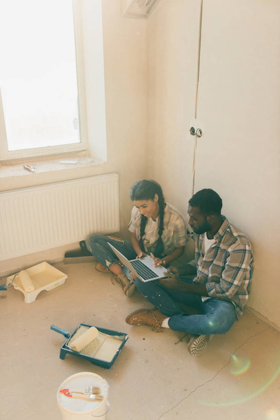 afro-amerikai házaspár pihenő-laptop-új otthon felújítása során magas szög kilátás - Fotó, kép