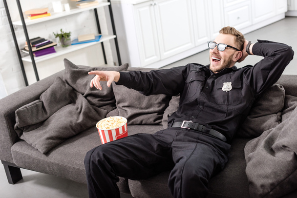 ソファに座って、映画の 3 d メガネの警官 - 写真・画像