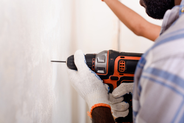 cropped image of man in protective gloves working with power drill  - Photo, Image