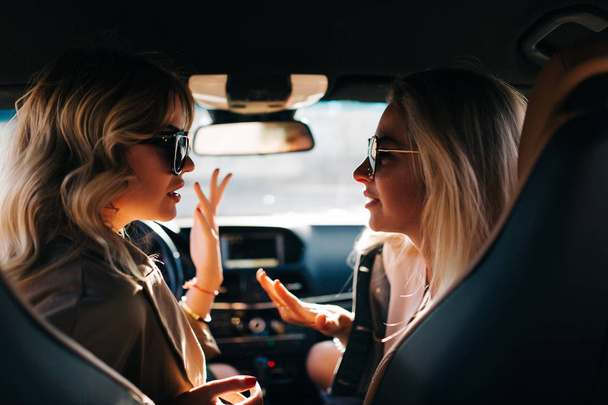 Photo of back of two talking women sitting in car in front seat - Fotoğraf, Görsel