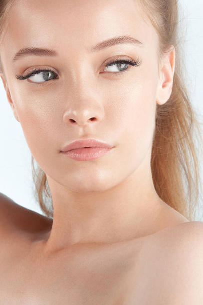 Young beautiful girl with clean perfect skin close-up. Beauty and care for young skin - 写真・画像