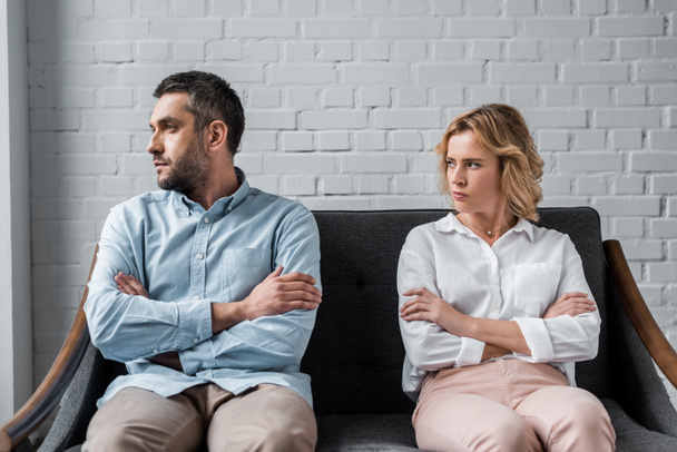angry couple sitting on couch after quarrel and looking away - Photo, Image