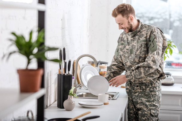 army soldier cleaning dishes in kitchen - Photo, Image