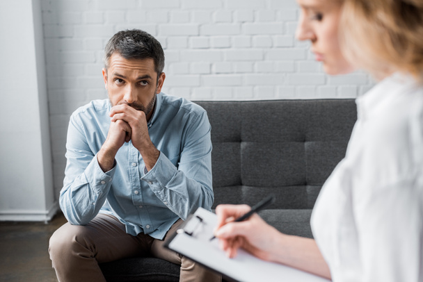 triest volwassen man op psycholoog therapie sessie op kantoor - Foto, afbeelding