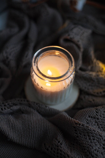 Homely decor. Candle in a glass jar, plaid, cotton, laptop. Cozy. Autumn. - Photo, image