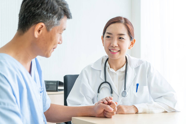 Asian female doctor and patient discussing something while sitting at the table - selective focus point - 写真・画像