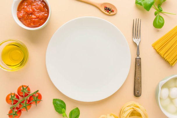 top view of fresh Italian pasta Ingredients with plate on bright background - Foto, Imagem