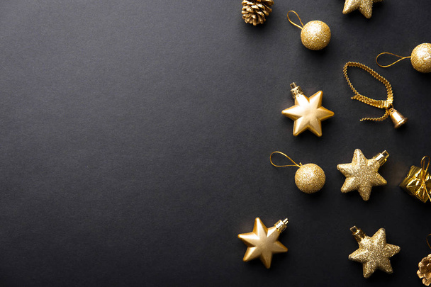 top view of beautiful christmas golden and silver decorative baubles on dark black background - Foto, Imagem