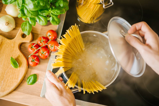cropped shot of man boiling homemade italian spaghetti - Zdjęcie, obraz