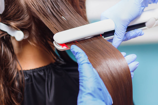 Кератиновое восстановление волос и протеиновое лечение с помощью профессионального ультразвукового железа - Фото, изображение